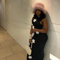 Side Angle of a Woman wearing Black High Neck Maxi Dress with 3D Flower