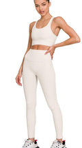 Side angle shot of a woman wearing a white emery athletic legging set.