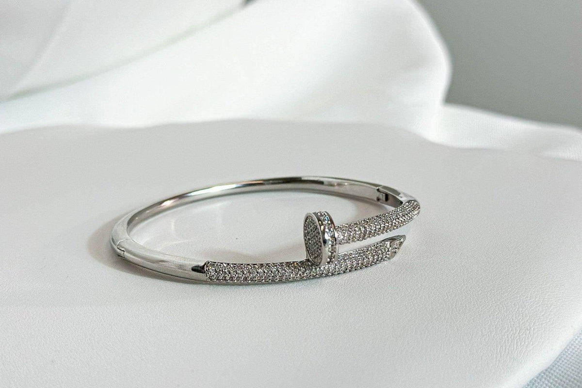 Silver Zircon Nail Cuff Bracelet with pave zircon stones and a stone-set nail head on white satin