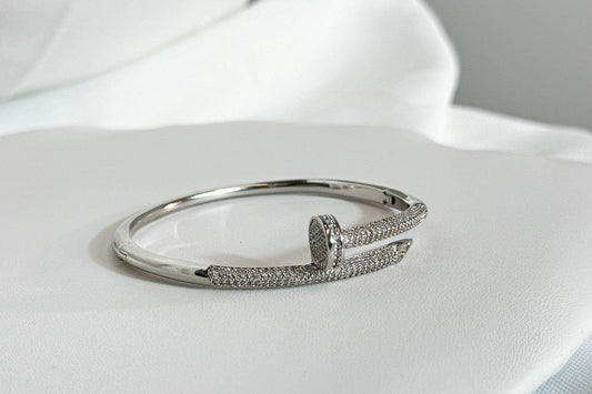 Silver Zircon Nail Cuff Bracelet with pave zircon stones and a stone-set nail head on white satin