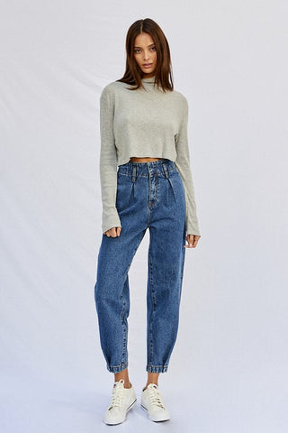 Full image of a woman wearing her High Pleated Waist Jogger Jeans