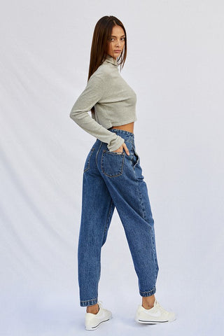 Back and side angle of a woman while wearing her High Pleated Waist Jogger Jeans