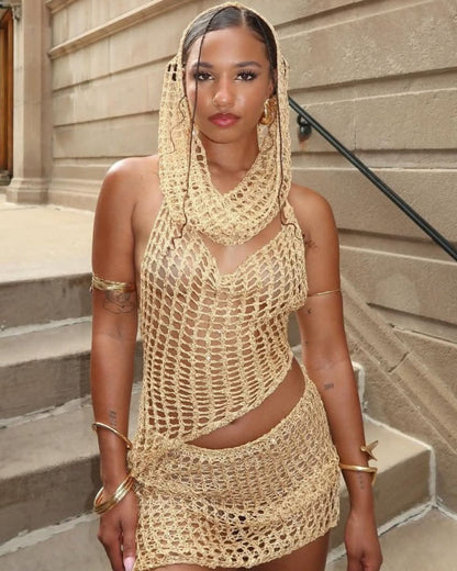 Woman wearing a beige crochet dress standing on steps.