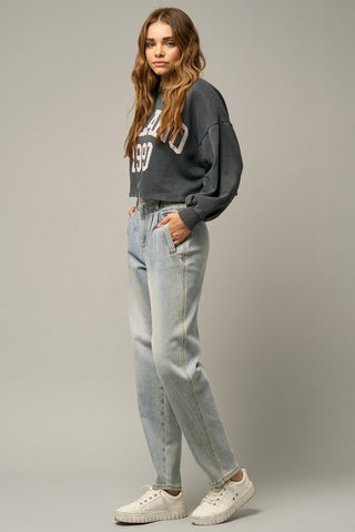 Full image of a woman wearing her High-Waisted Balloon Jeans from the side angle