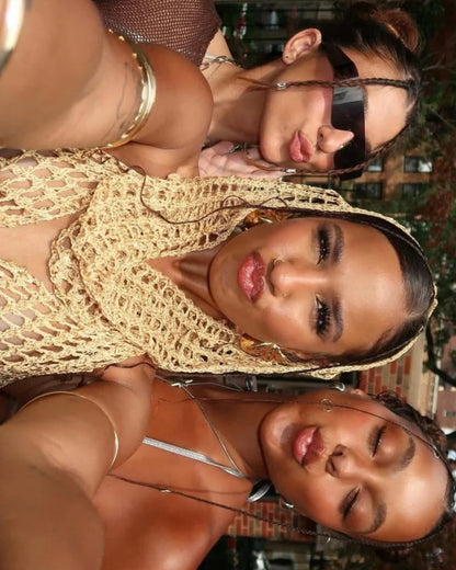 Two women posing closely together outdoors with a blurred background