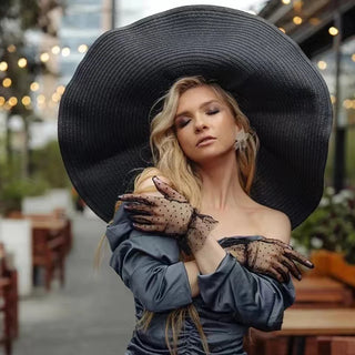 Front angle image of a woman wearing a black Wide Paper Straw Hat.