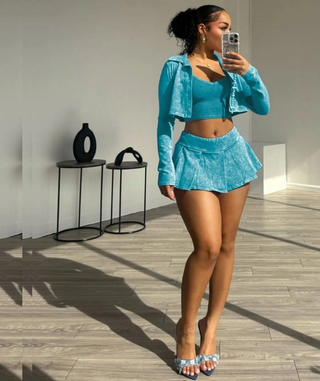 Full image of a woman wearing teal Three-Piece Acid Wash Set with Mini Pleated Skirt