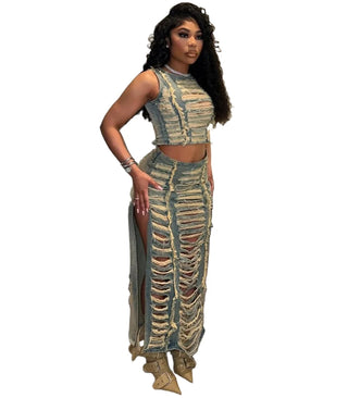 Side view of a woman wearing a ripped denim crop top and a side slit long skirt.