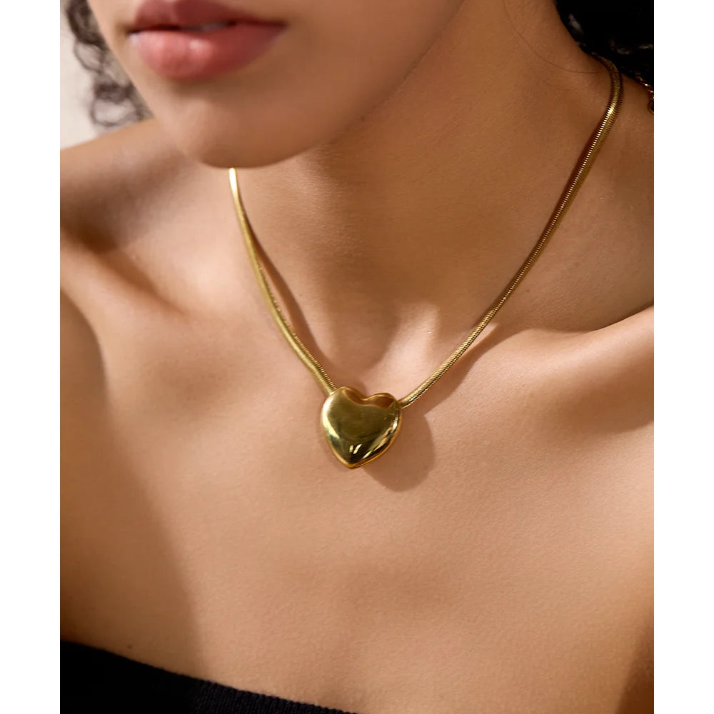 Close-up photo of a woman wearing the Gold Color of Snake Chain Necklace with Heart Pendant